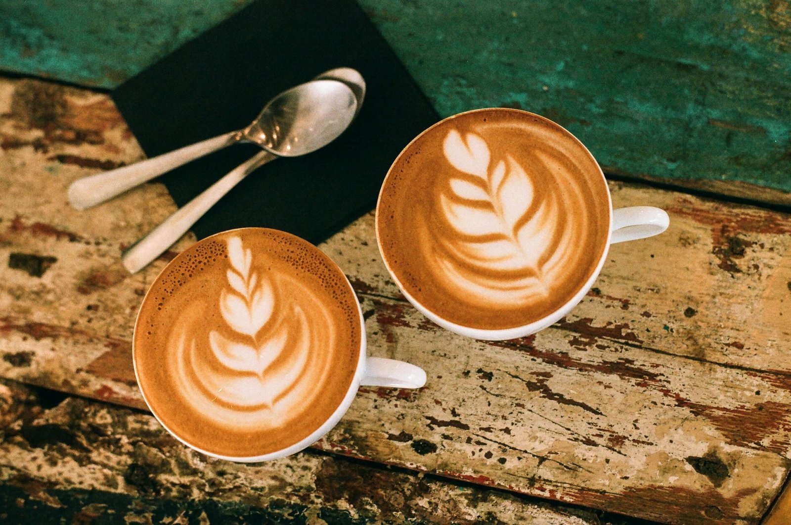 Café latte art on rustic table in Paris, capturing warm coffee moments.